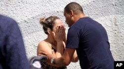 A man comforts a woman at the Raul Brasil State School in Suzano, Brazil, Wednesday, March 13, 2019. 
