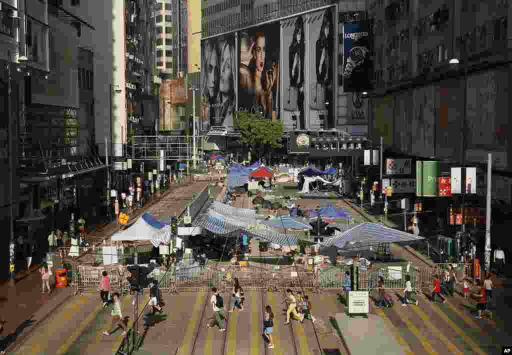 Students walk past barricades on a main road in the occupied areas of the Causeway Bay district in Hong Kong, Oct. 10, 2014.