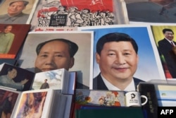 2018年2月26日，北京一个市场陈列的中国国家主席习近平像和前共产党领袖毛泽东像。