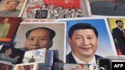2018年2月26日，北京一个市场陈列的中国国家主席习近平像和前共产党领袖毛泽东像。毛泽东终身执政，掌权到死。