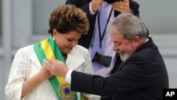 Newly sworn-in Brazilian President Dilma Rousseff (L) receives the presidential sash from outgoing President Luiz Inacio Lula da Silva at the Planalto Palace in Brasilia, 1 Jan 2011