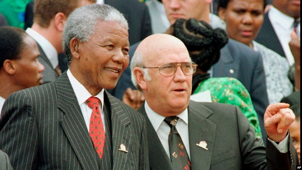 South African President Nelson Mandela, left, and Deputy President F.W. de Klerk chat outside Parliament after the approval of South Africa's new constitution May 8, 1996. (AP Photo, file) 