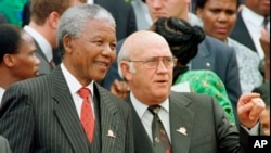 FILE - South African President Nelson Mandela, t, and Deputy President F.W. de Klerk chat outside Parliament after the approval of South Africa's new constitution, May 8, 1996. 