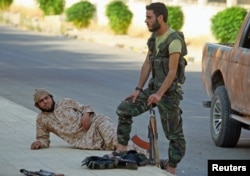 FILE - Fighters from a coalition of rebel groups rest in July 2015 in the Hama countryside, Syria.