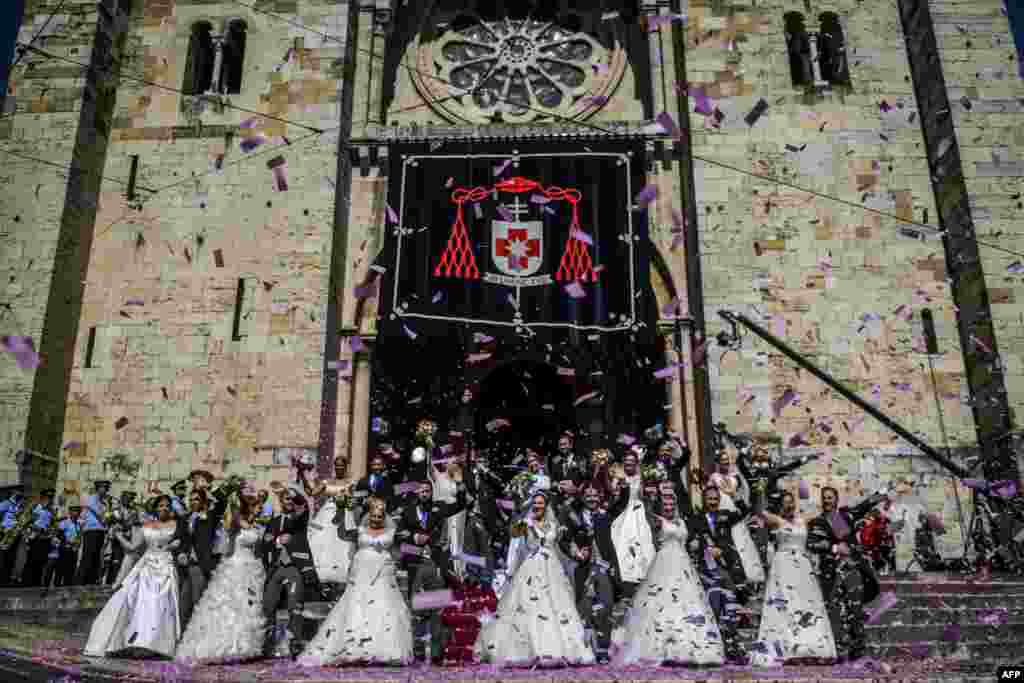 Brides and grooms pose for a photo outside the Lisbon&#39;s cathedral following their wedding ceremony in Lisbon, Portugal, June 12, 2019.