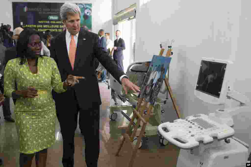 U.S. Secretary of State John Kerry and entrepreneur Patricia Nzolantima point at an ultrasound machine during a tour of a Sustainable Investment in Sub-Saharan Africa medical supply store in Kinshasa, DRC, May 3, 2014.