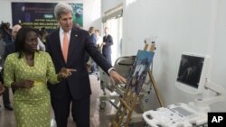 FILE - U.S. Secretary of State John Kerry and entrepreneur Patricia Nzolantima point at an ultrasound machine during a tour of a Sustainable Investment in Sub-Saharan Africa medical supply store in Kinshasa, DRC, May 3, 2014.