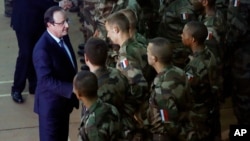French President Francois Hollande, left, addresses the troops during a stopover from South Africa in Bangui, CAR, Dec. 10, 2013. 