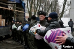 Members of the Ukrainian National Guard load humanitarian aid parcels for the government-held industrial town of Avdiyivka to a truck in Kyiv, Ukraine, Feb. 3, 2017.