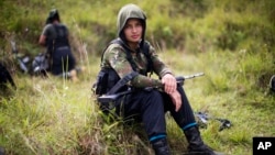 Juliana, a 20-year-old rebel fighter for the 36th Front of the Revolutionary Armed Forces of Colombia, or FARC, rests from a trek in the northwest Andes of Colombia, Jan. 6, 2016.