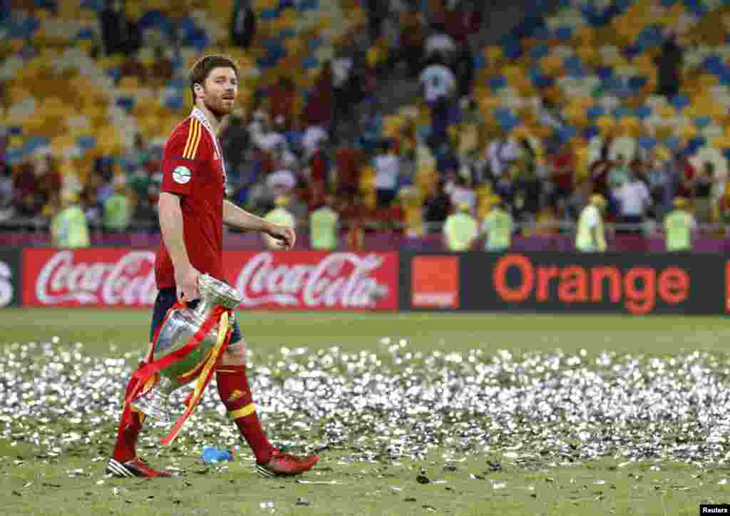 Spain's Xabi Alonso celebrates with the trophy after defeating Italy to win the Euro 2012 final soccer match at the Olympic stadium in Kiev, July 1, 2012.