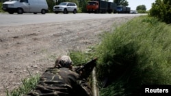 A pro-Russian rebel takes his position at a front line rebel position near the eastern Ukrainian town of Slovyansk May 16, 2014. 