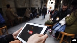 A man tries to connect to YouTube with his tablet at a cafe in Istanbul, March 27, 2014.