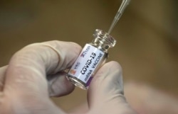 Seorang teknisi laboratorium mengambil sebagian isi dari kandidat vaksin Covid-19 untuk diuji di Pusat Penelitian Vaksin Chula di Universitas Chulalongkorn, di Bangkok, Thailand, 25 Mei 2020. (Foto: AP)
