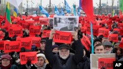 People hold posters reading "Who ordered the murder?" during a rally in memory of opposition leader Boris Nemtsov in St. Petersburg, Russia, Feb. 26, 2017. Thousands of Russians have taken to the streets of Moscow and St. Petersburg to mark two years since Nemtsov was gunned down outside the Kremlin. (AP Photo/Dmitri Lovetsky)