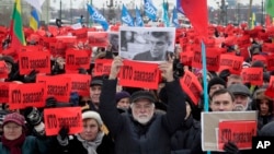 People hold posters reading "Who ordered the murder?" during a rally in memory of opposition leader Boris Nemtsov in St. Petersburg, Russia, Feb. 26, 2017.
