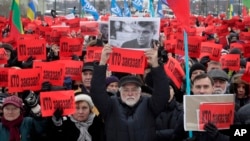 Người biểu tình giơ những bảng biểu với dòng chữ "Ai đã ra lệnh vụ ám sát?" ở St. Petersburg, Nga, 26/2/2017.