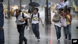 Các du khách buộc phải đội mưa khi cơn bão Saola ập đến Đài Bắc, Đài Loan hôm 01/08/2012