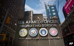 FILE - The Times Square military recruiting station displays insignia for each military branch in New York, July 15, 2015.