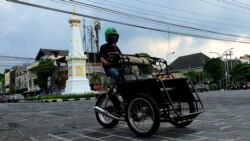 Becak motor melintas di Tugu Yogya yang mulai ramai oleh lalu lintas. (Foto: VOA/ Nurhadi)