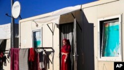 지난달 17일 터키-시리아 접경 지역의 난민수용소에서 한 여성이 임시 거처로 사용 중인 컨테이너 밖을 내다보고 있다. (자료사진)