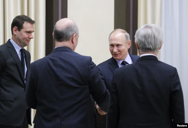 Russian President Vladimir Putin (back) greets (L-R) Alexandre Ricard, Member of Executive Board at Pernod-Ricard company, Nicolas Maure, CEO of AvtoVAZ, and Regis Monfront, Deputy CEO at Credit Agricole Corporate and Investment Bank, as he meets with representatives of the French and Russian business communities at the Novo-Ogaryovo state residence outside Moscow, Russia, Jan. 31, 2018.