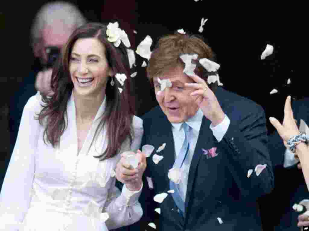 Singer Paul McCartney and his bride Nancy Shevell are showered in confetti as they leave after their marriage ceremony at Old Marylebone Town Hall in London October 9, 2011. Former Beatle Paul McCartney wed for the third time on Sunday when he and New Yor