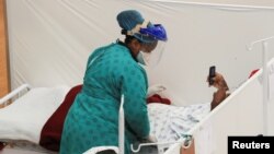 Un agent de santé traite un patient dans un hôpital de campagne temporaire mis en place par Médecins Sans Frontières lors de l'épidémie de maladie à coronavirus dans le canton de Khayelitsha près du Cap, en Afrique du Sud, le 21 juillet 2020.