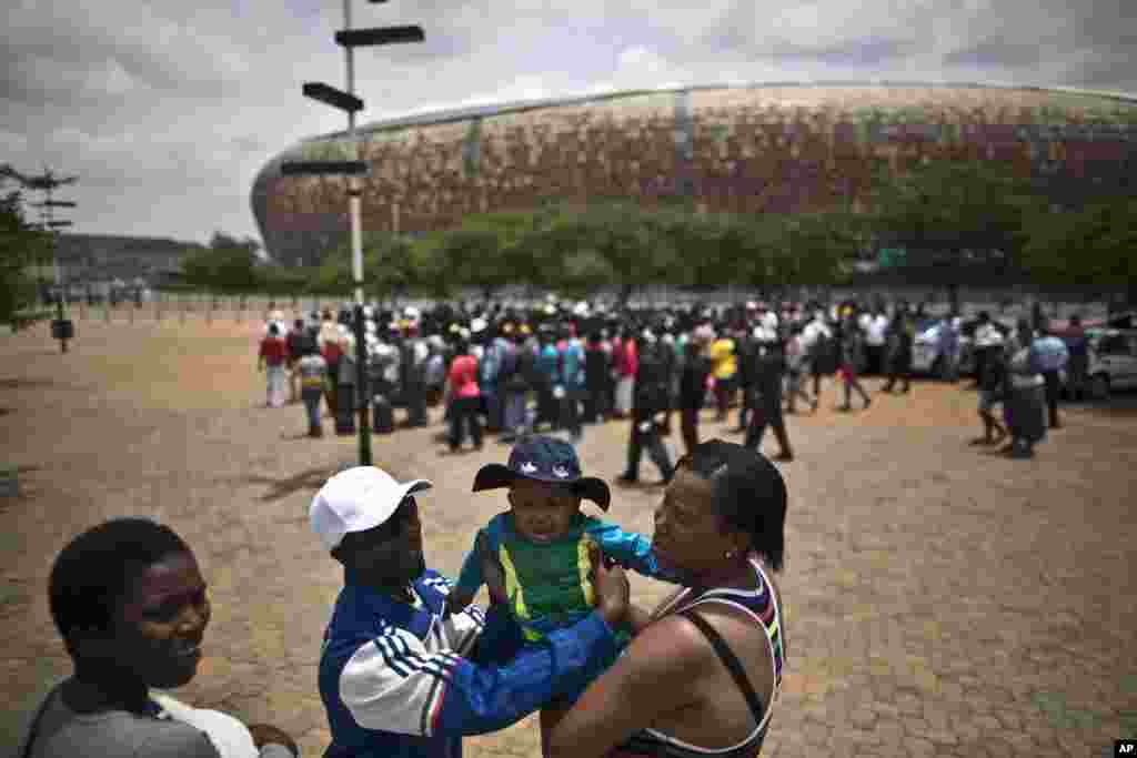 Um casal com a sua bebé à porta do Estádio FNB onde decorreu a cerimónia fúnebre de Estado, de Nelson Mandela, nesta terça-feira. Dez. 9, 2013.