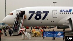 Hành khách chuyến bay Dreamliner 787 của hãng ANA được đoàn múa lân chào đón tại sân bay quốc tế Hong Kong. ANA và Japan Airlines đã cho ngưng hoạt động tất cả 24 máy bay Dreamliner.