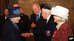 FILE - Britain's Queen Elizabeth II, left, meets Holocaust survivor Gena Turgel during a service to remember victims of the Holocaust in Westminster Central Hall in London on the 60th anniversary of the liberation of Auschwitz, Jan. 27, 2005. Turgel, who comforted diarist Anne Frank at the Bergen-Belsen concentration camp months before its liberation, has died. She was 95. 