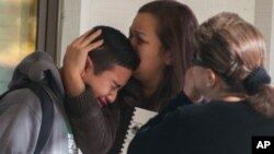 A Sparks Middle School student cries and is comforted after being released from Agnes Risley Elementary School, where some students were evacuated to after a shooting at the school in Sparks, Nevada, Oct. 21, 2013.