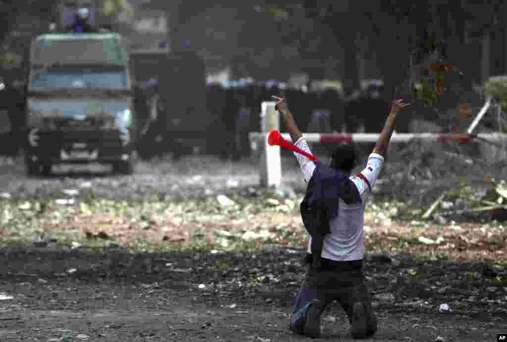 An Egyptian protester blows a stadium horn as he gestures at a cordon of security forces near Tahrir square, Cairo, Egypt, November 27, 2012. 