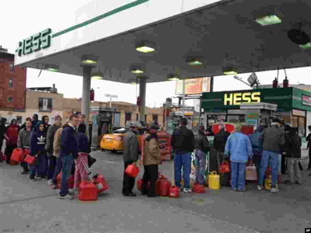 Shortly before the gas ran out, customers wait in line at a Hess station where the line of cars snaked 10 blocks, and at least 60 people waited to fill red gas cans for their generators, in the Gowanus section of Brooklyn, New York, Friday morning, Nov. 2, 2012. Courier Winston Alfred said he had been there in his van since 4:20 am, and was second in line, when he was turned away four hours later. (AP Photo/David Caruso)