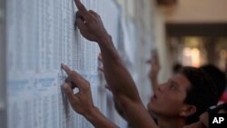 Voters search the electoral rolls for the location of their respective polling table during general elections in Managua, Nicaragua, Sunday Nov. 6, 2011.