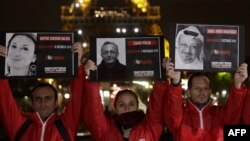 Manifestantes sostiene retratos de periodistas muertos frente a la Torre Eiffel durante un evento organizado por la ONG Reporteros sin Fronteras el 1 de noviembre de 2018 en París, en la víspera del Día Internacional para Poner fin a la Impunidad de los Delitos contra Periodistas. 