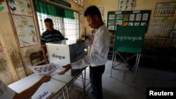 Para petugas pemilu mempersiapkan bilik suara di dalam ruang kelas di sekolah yang dipilih menjadi salah satu TPS di Phnom Penh, Kamboja, 28 Juli 2018.