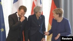 Presiden Perancis Emmanuel Macron (kiri), bersama PM Inggris Theresa May dan Kanselir Jerman Angela Merkel berbincang sebelum dimulainya KTT Uni Eropa-negara-negara Balkan Barat di Sofia, Bulgaria, 17 Mei 2018. 