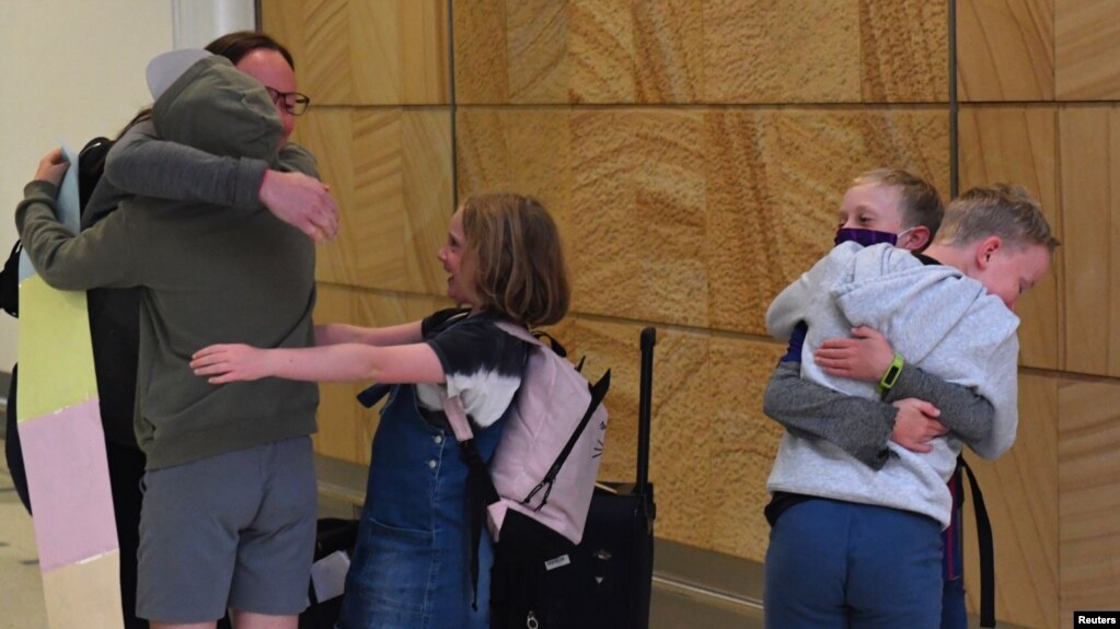 来自新西兰的旅客2021年4月19日在抵达悉尼国际机场时与亲人拥抱团聚（路透社）(photo:VOA)