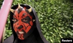 A woman dressed as the character Darth Maul attends the rollout of products in advancement of the film "Star Wars: The Force Awakens" on "Force Friday" in Sao Paulo, Brazil, Sept. 4, 2015.