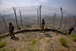 FILE - Pakistan Army troops patrol along the fence on the Pakistan-Afghanistan border at Big Ben hilltop post in Khyber district, Pakistan, Aug. 3, 2021.