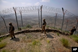 FILE — Pakistan troops patrol along the fence on the Pakistan-Afghanistan border at Big Ben hilltop post in Khyber district, Pakistan, Aug. 3, 2021.