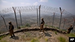 FILE - Pakistan Army troops patrol along the fence on the Pakistan-Afghanistan border at Big Ben hilltop post in Khyber district, Pakistan, Aug. 3, 2021.