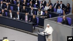 German Chancellor Angela Merkel, center left, and her government listen to Pope Benedict XVI, center, as he delivers his speech at the German parliament Bundestag in Berlin, Germany, Sept. 22, 2011.