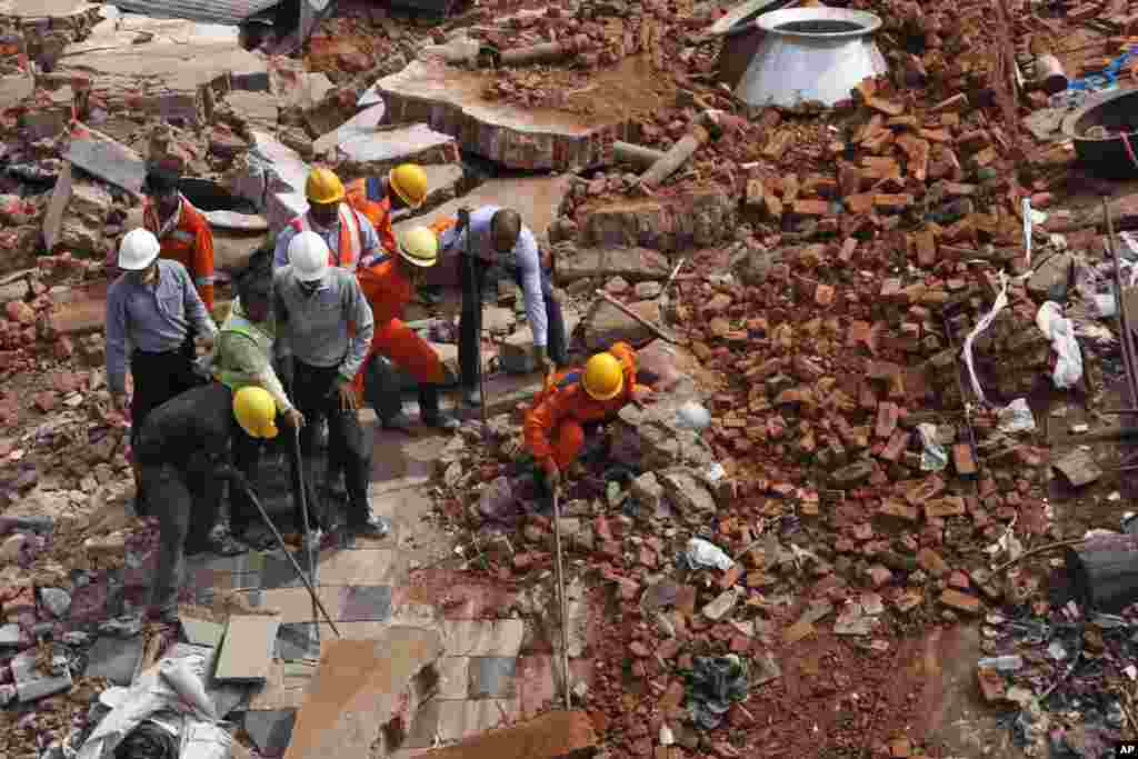 Rescue workers look for survivors from the debris of a collapsed building, in Secunderabad outside Hyderabad, India, July 8, 2013.