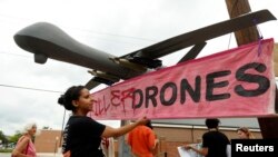 Beberapa demonstran membawa tulisan "Stop Killer Drones" (Hentikan Pesawat Tanpa Awak Pembunuh) di Fort McNair, di mana Presiden Barack Obama memberikan pidato (23/5). 