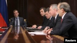 Russian Prime Minister Dmitry Medvedev (L) chairs a meeting with his deputies at the Gorki state residence outside Moscow, March 25, 2013.