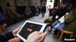 A man tries to get connected to YouTube with his tablet at a cafe in Istanbul, March 27, 2014.