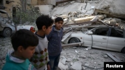 Children are seen near rubble after an airstrike in the besieged town of Douma, in eastern Ghouta, near Damascus, Syria, Feb. 6, 2018.