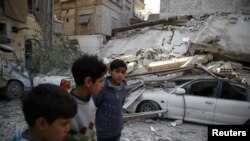 Children are seen near rubble after an airstrike in the besieged town of Douma, in eastern Ghouta, near Damascus, Syria, Feb 6, 2018.